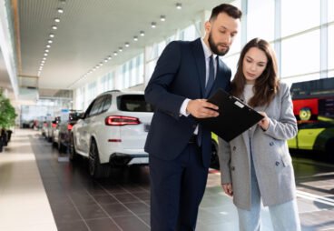 an-employee-of-an-insurance-company-offers-to-purchase-policy-in-car-dealership